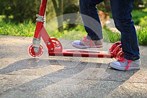 Child feet on a kick scooter