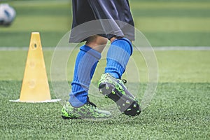 Child feet practicing running and moving on soccer field