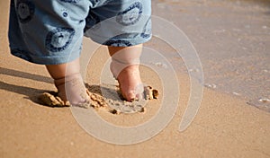 Child feet at the sand