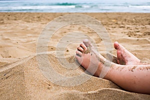 Child feet in the sand on a beach.