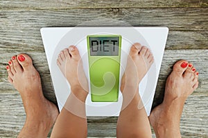 Child feet standing on digital weight scale in front of his mother, diet recommendation