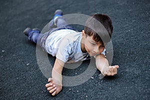 The child fell and hit his hand, the boy stumbled and fell on the sidewalk.
