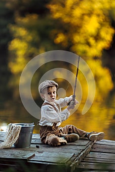 Child fishing at autumn lake