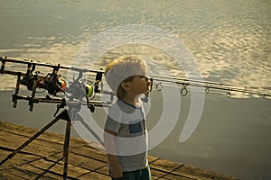 Child is fishing. Boy stand on fishing pier