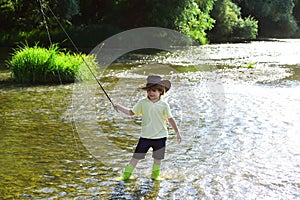Child fishing. Kid learning how to fish holding a rod on a river. Little boy fisherman with fishing rod. Young man fly