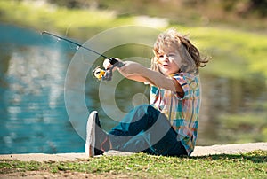 Child fishing on the lake. Kid fisher boy with spinner at river. Portrait of excited boy fishing. Boy at jetty with rod