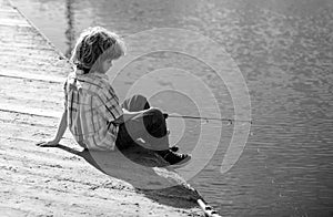 Child fishing at river or lake. Young kid fisher. Summer outdoor leisure activity. Little boy angling at river with rod.