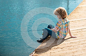 Child fishing at river or lake. Young kid fisher. Summer outdoor leisure activity. Little boy angling at river with rod.