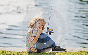 Child fishing at river. Young kid fisher. Summer outdoor leisure activity. Little boy angling at river bank with rod.