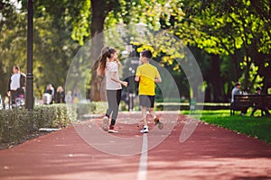 Child fitness, twins kids running on stadium track in city park , training and children sport healthy lifestyle. Outdoor