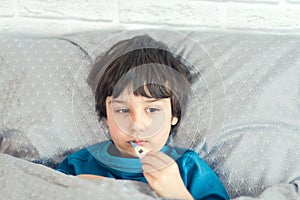 Child flu sick, boy with medical thermometer in mouth, health illness. Kid with cold rhinitis, get cold