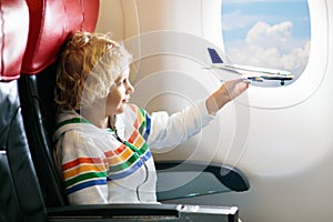 Child flying in airplane. Flight with kids