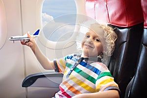 Child flying in airplane. Flight with kids