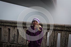 Child by foggy bridge