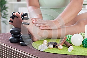 Child foot ready to spa treatment with massage stones