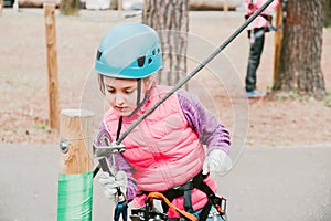 A child in a forest adventure Park. Rock climbing outdoor entertainment center for children. School yard Playground with rope path
