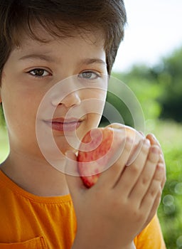 A child with a fruit. Kid eating fresh pear. Happy boy biting apple