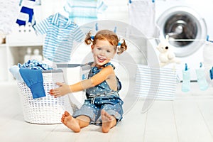 Child fun happy little girl to wash clothes in laundry room
