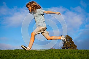 Child fun run outdoors. Kid playing in summer park. Little boy running on green fresh grass field.