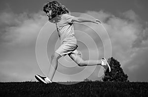 Child fun run outdoors. Kid playing in summer park. Little boy running on green fresh grass field.