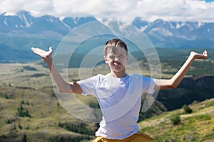 A child funny boy on the Altai mountain background.