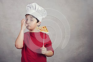 Child funny cook with slice pizza