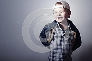 Child. Funny Little Boy in Jeans. Trucker cap. joy. Fashionable Kid. plaid shirt. Denim Wear