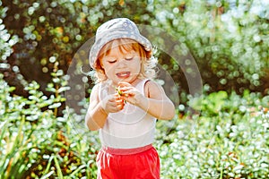 child in the garden with berries