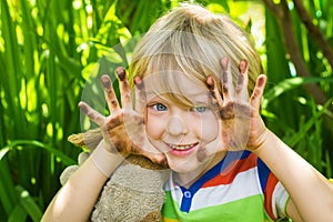 Child in garden with dirty hands