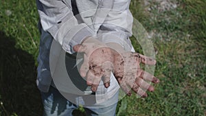 Child in garden showing dirty hands evidence of their diligent work in garden. Childs dirty hands in garden tells story