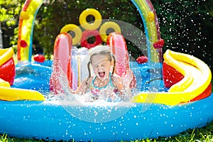 Child in garden swimming pool with slide