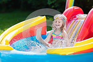 Child in garden swimming pool with slide