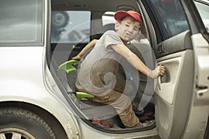 The child gets out of the car. The boy got into the vehicle