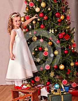 Child with gift box near Christmas tree