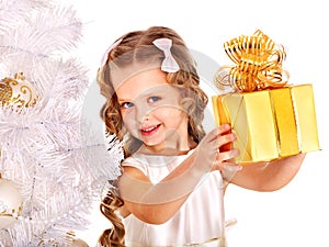 Child with gift box near white Christmas tree.