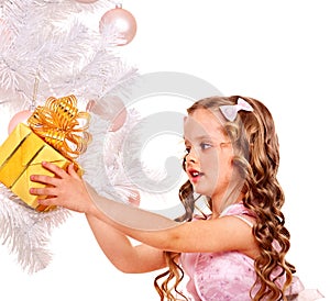 Child with gift box near white Christmas tree.