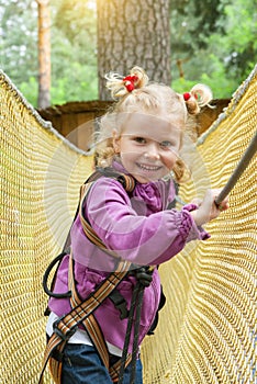 The child girl is 4 years old in adventure climbing high wire park, active lifestyle of children