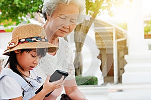 Child girl is addictive, have an elderly grandmother sit photo