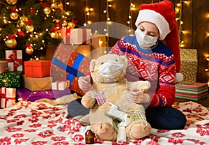 Child girl as Santa helper posing in new year decoration. Wearing a protective face mask against viruses, coronaviruses. She plays