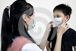 Child girl or big sister is wearing medical mask to prevent disease and flu for little brother during back to school,semester