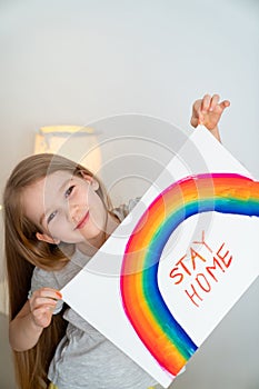 Child girl drew rainbow and poster stay home. photo