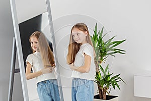 Child Girl Brushing Hair in Mirror. Morning preparation before school