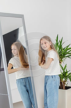 Child Girl Brushing Hair in Mirror. Morning preparation before school