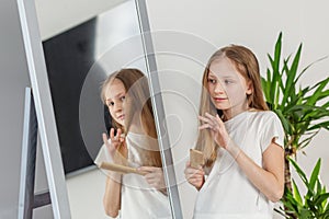 Child Girl Brushing Hair in Mirror. Morning preparation before school