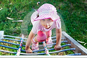 Child girl climbing by the rope ladder