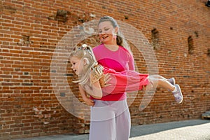 Child girl with cochlear implant with her mother spend time outdoor. Hear impairment and deaf community concept. Deaf