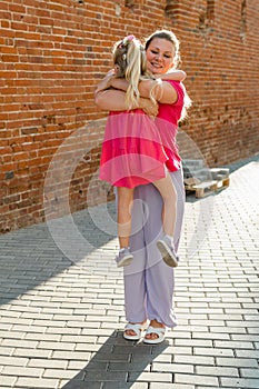 Child girl with cochlear implant with her mother spend time outdoor. Hear impairment and deaf community concept. Deaf