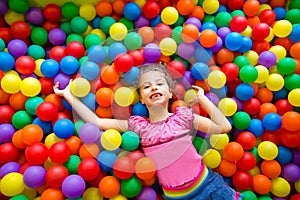 Child girl on colorful balls playground high view