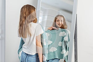 Child Girl Contemplating Clothing Choice in Mirror. Morning preparation before school