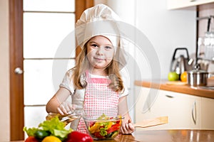 Child girl cooking at kitchen